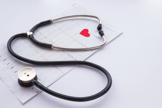 Stethoscope, cardiogram and the image of the heart on  light bac