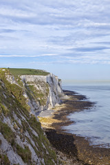 Fototapeta na wymiar White cliffs of Dover, rocky beach, on a cloudy summer day, England