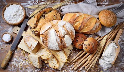 Assorted bread on wooden background, top view.