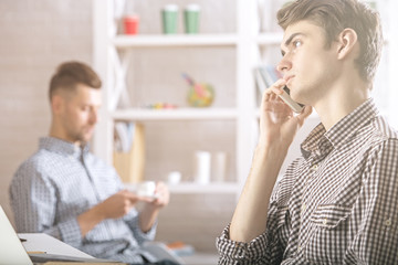 Men talking on phone at workplace