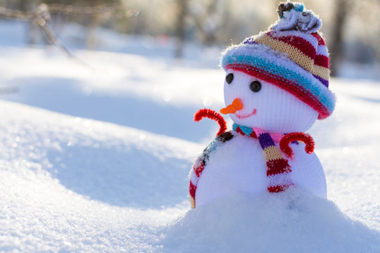 Маленький игрушечный снеговик в снегу в парке