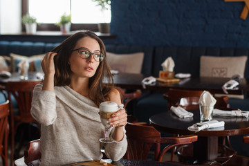 woman drinking coffee in the morning at restaurant (soft focus on the eyes)