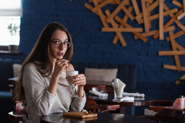woman drinking coffee in the morning at restaurant (soft focus on the eyes)