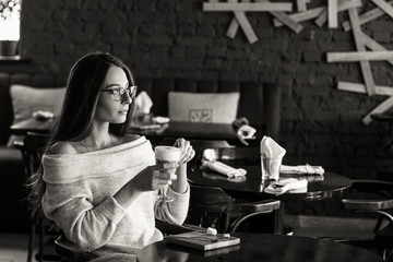 woman drinking coffee in the morning at restaurant (soft focus on the eyes)