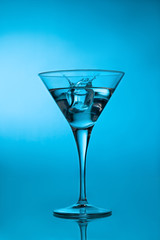 Ice cube splashing martini cocktail