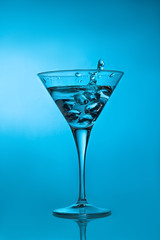 Ice cube splashing martini cocktail