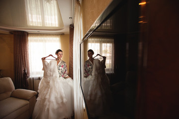 Fototapeta premium Bride with wedding dress and bride's reflection