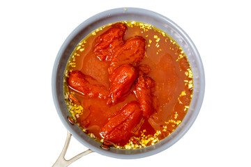 Canned tomatoes, garlic are fried in oil in a frying pan.