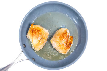 Chicken thigh fried in a skillet. Insulated