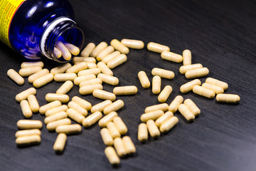 Capsules with bootle isolated on black background