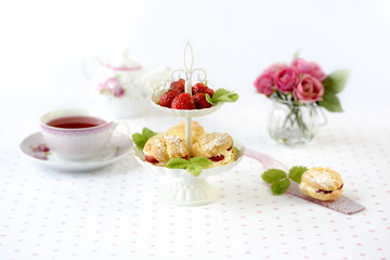 Profiterole or cream puffs cakes filled with whipped cream, strawberries in plateau