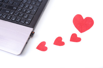 Red heart with laptop on wooden table