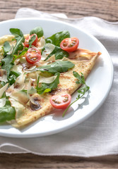 Crepes with cherry tomatoes, italian cheese and arugula