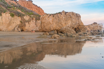 Fototapeta na wymiar Cliffs and Rocks reflected in low tide on the shores of the pacific ocean at El Matador State Beach Califonia