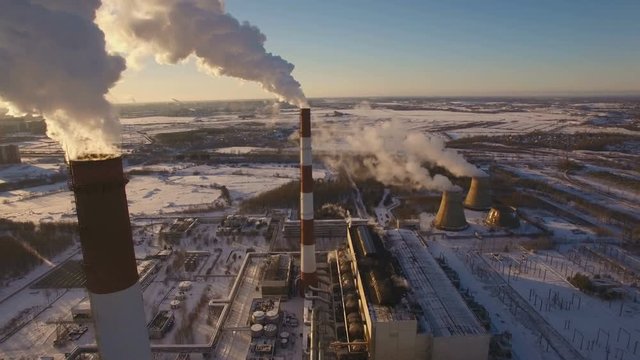 Smoking chimneys power station on sunset background in the winter. Aerial view