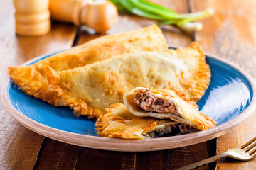 Russian, Turkish, Ukrainian and Tatar national meal cheburek. Traditional east cuisine food. Meat pastry on a table.