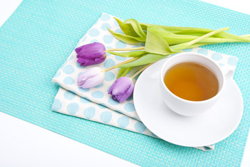 Tableware in polka dots, a cup of tea and pink tulips