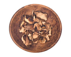 Dried porcini mushroom in wooden bowl isolated on white background