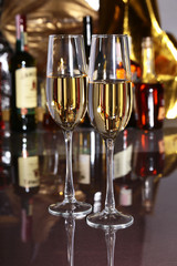 Glass of wine, brandy or cognac on the mirror wooden table