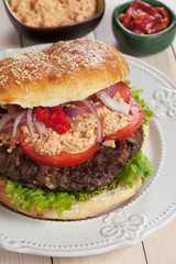 Pljeskavica, serbian burger with urnebes topping