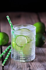 Homemade iced lemonade lime in a crystal glass on the old wooden background.