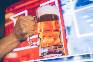Draft Beer with a tv screen sports background