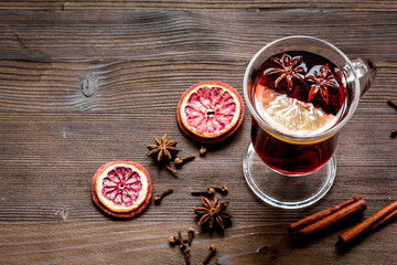 mulled wine with spices in cup wooden background top view