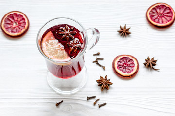mulled wine with spices in cup on wooden background
