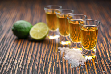Glasses gold tequila with green lime ,selective focus