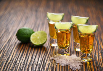 Glasses gold tequila with green lime,selective focus