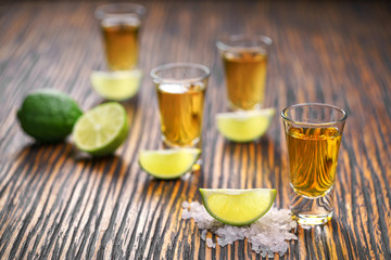 Glasses gold tequila with green lime   ,selective focus