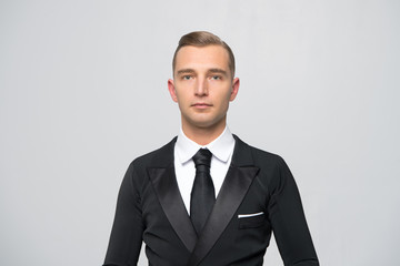 Confident attractive young man in tuxedo