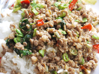 Rice topped with stir-fried pork and basil closeup