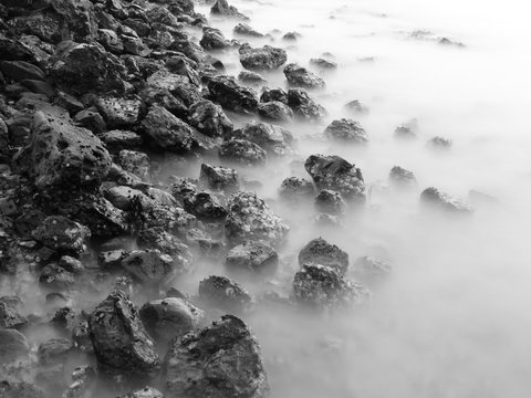 Fototapeta Long exposure black and white image of stone in the sea