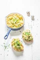 Tasty scrambled eggs with avocado for breakfast