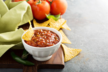 Red tomato spicy salsa with chips