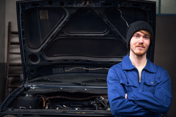 Fototapeta na wymiar Mechanic Posing In Front Of A Car