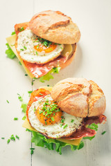 Tasty burger with lettuce, bacon and eggs