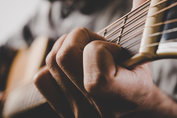Close up of man hand playing guitar.