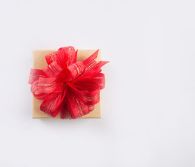 Red gift box with gold bow, isolated isolated on white.