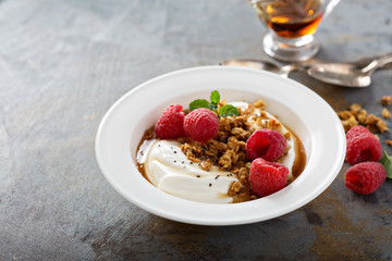 Yogurt bowl with raspberry and maple syrup