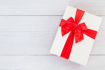 Top view color gift box with ribbon on white wooden plank