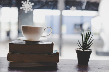 Vintage color Cup of coffee with book in coffee shop.