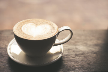 Vintage tone of hot coffee latte art in heart shape in cup.