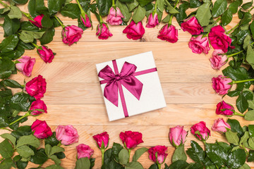 Fresh pink rose flower and gift box on wooden deck. For love or