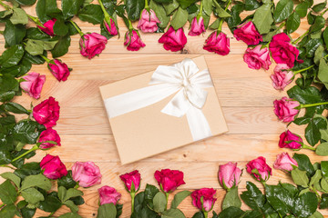 Fresh pink rose flower and gift box on wooden deck. For love or