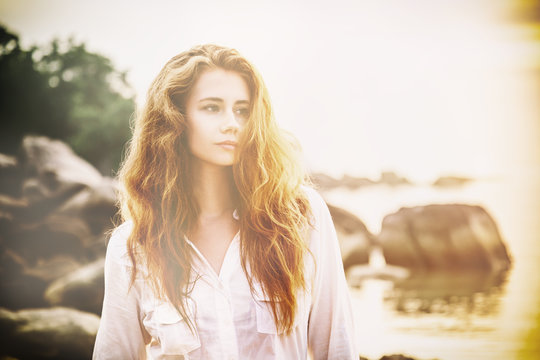 Beautiful Young Woman With Long Red Hair On The Beach At Sunset