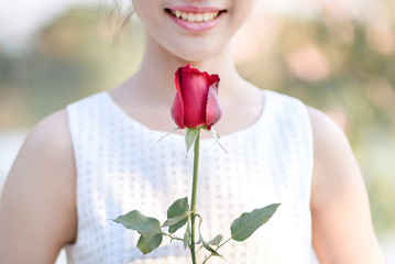 Woman hugging red roses with pleasure.