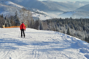 Fototapeta na wymiar Back view man skiing in snowy winter day. Winter and snow sport , winter landscape