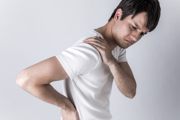 young man having horribly stiff shoulders